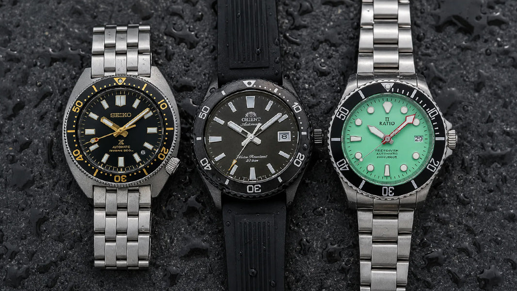 Seiko Prospex Turtle, Orient Mako, and Ratio FreeDiver flat-lay on dark wet surface